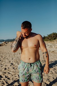 Tattooed man standing at the beach