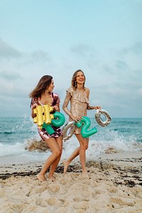 Girls carrying a 2020 foil balloon at the beach party