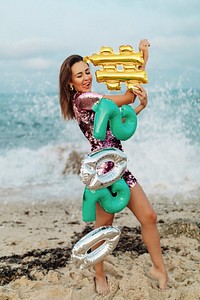Girl carrying a #2020 foil balloon at the beach party