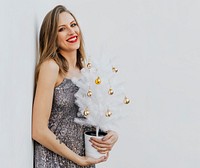 Woman holding a small white Christmas tree