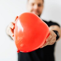 Man showing heart shape red balloon