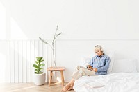 Blond haired Asian woman listening to music on a white bed