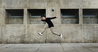 Carefree man jumping mid-air, city photo