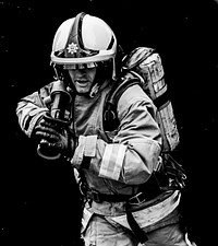 Firefighter holding water hose, June 1, 2019, Cheshire, UK. Original public domain image from Flickr