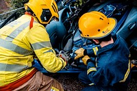 Firefighter fixing car. Original public domain image from Flickr