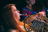 Woman playing French horn, October 15, 2019, UK. Original public domain image from Flickr