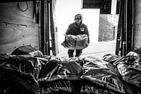 Woman moving plastic sack in truck, May 4, 2020, Cheshire, UK. Original public domain image from Flickr