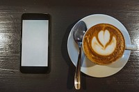 Mobile phone mockup by a coffee cup
