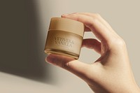 Cosmetic jar mockup, beauty product packaging psd, held by hand in natural light