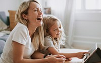 Mother and daughter watching cartoon on digital tablet