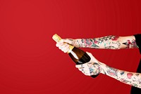 Tattooed hands popping a champagne