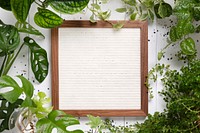 Picture frame mockup psd with leaves around flat lay