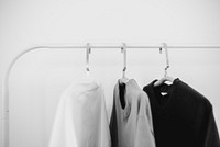 T-shirts on clothing rack, minimal gray photo