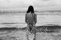 Woman wearing swimsuit at beach, gray photo