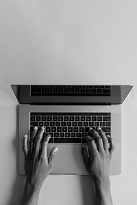 Black hands typing on laptop