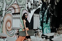 Woman carrying skateboard, Venice Beach, LA