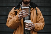 Tourist holding stacked coffee cups