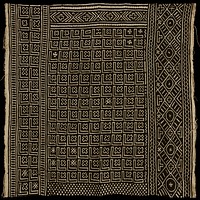 black and tan textile; constructed of eight long strips stitched together; short edges have fringe; textile is decorated with the recurring symbols of an "x" and a line bent at a right angle; other designs that occur are crosses, chevrons, zig zags, and diamonds. Original from the Minneapolis Institute of Art.