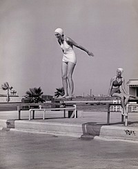 Women on diving board at swimming pool, vintage black and white photo, remix composite image.