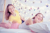 Happy sisters chilling in bed, aesthetic bedroom