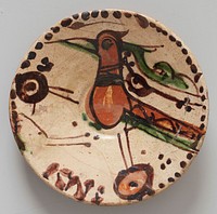 Bowl, shallow; of red earhtenware, glazed and decorated on upper side only; cream-colored ground. Center decoration large burnt umber bird, crudely outlined in brown; green beak ad tail feathers. Border consists of brown dots of uneven size, crudely applied. Low foot. From Amol. Strong resemblance to bowl in Sam Lewisohn Collection, N.Y.C., shown in Illustrated London News, Jan. 10,1931, P.63. Low foot, unglazed.. Original from the Minneapolis Institute of Art.