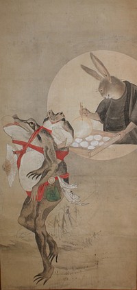 Frog at LL strutting on two long legs, holding open fan in PR hand, balancing white mochi in mouth; young frog swaddled to back with red cords carrying bag of mochi balls; rabbit in black robes in round vignette at UR fanning tray of white mochi balls. Original from the Minneapolis Institute of Art.