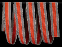 long strip of woven fabric; black and white stripes flanking four central orange stripes with thin black and white stripes between. Original from the Minneapolis Institute of Art.