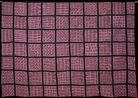 large panel with two selvedges and two hemmed edges (hemmed in red and white machine stitches); lavender fabric separated into blocks with strips of appliqued black cloth; stamped designs on each block in brown--X's, suns shapes, leaves, swirls, circles, etc.. Original from the Minneapolis Institute of Art.