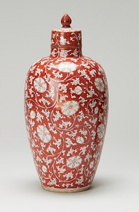 Red ground with white scrolling floral design overall; teardrop-shaped finial; looped design on top of cover; pair of blue concentric circles on underside. Original from the Minneapolis Institute of Art.