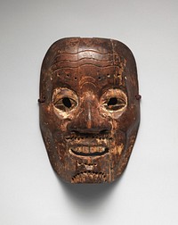 Mask of male face with large nose, round eyes with carved out eyeholes; narrow grin with top teeth visible; wrinkles in forehead; holes drilled into eyebrows, moustache, and chin possibly once for hair. Original from the Minneapolis Institute of Art.
