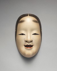 Mask of a slightly smiling female face; lips slightly parted with black teeth; eyes looking straight forward; painted eyebrows near top of forehead; painted black hair framing face; ivory pigment with gray shading. Original from the Minneapolis Institute of Art.