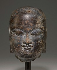 mottled grey and brown stone; placid face with closed wide eyes, broad nose, full lips, long ears with elongated lobes; bald. Original from the Minneapolis Institute of Art.