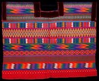 two panel huipil; supplementary weft patterning on red ground cloth with applied red velvet at neck opening and armholes; geometric patterns cover entire garment, primarily diamonds, chevrons and zigzags, separated by stripes of plain weave; designs in orange, yellow, lavendar, purple green, blue.. Original from the Minneapolis Institute of Art.