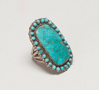 four branched band silver ring with large square Blue Gem turquoise surrounded by 28 small oval turquoises. (central stone somewhat loose) J. #963,Cat# 820, Illus p. 176. Original from the Minneapolis Institute of Art.