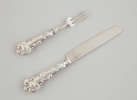 rounded knife blade; 3-pronged fork; each handle has same design on front and back which includes a scallop-shape at top and bottom; box is red with brown lining. Original from the Minneapolis Institute of Art.