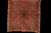 kussaba or square shawl; the ground is of black wool, parts of which have been woven separately and fastened together; shawl is completely covered with floral and arabesque designs; border woven separately and added; supplementary border of fringed strips of colored woolen; the design has been outlined in embroidered stitch; alike on both sides. Original from the Minneapolis Institute of Art.