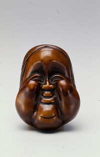 Top side carved with smiling mask with protruding cheeks and forehead; bottom side carved with female genitalia and hand. Original from the Minneapolis Institute of Art.