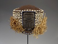 small, flat face with flat nose, slit eyes and small open mouth; large cloth head covering decorated with shells and beads; loose raffia strands on sides and back. Original from the Minneapolis Institute of Art.