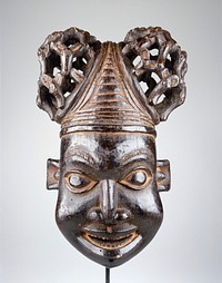 smiling face with slightly open mouth, flat nose and openwork hairstyle with two buns; protruding ears. Original from the Minneapolis Institute of Art.