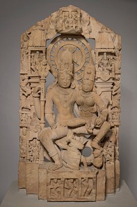 husband and wife seated on a lotus in the pose of royal ease and intimacy with bull and tiger underfoot; symmetrical architectural backdrop with large central disc behind heads of main figures. Original from the Minneapolis Institute of Art.