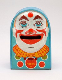 light blue rectangular box with round roof; face of clown on front side; clown has pointed triangular eyebrows and a red dot between them; front and back have red, yellow and green circles with rings around them. Original from the Minneapolis Institute of Art.