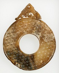 Tannish brown jade with dark brown clouds, partially calcified. Decor field is spiral grain design. Both sides of disc are identical.. Original from the Minneapolis Institute of Art.