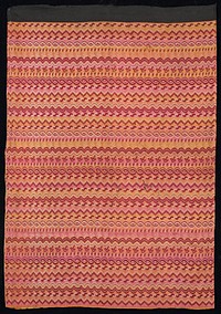 overshot (false Luntaya); pink and yellow plaid center panel with repeating horizontal patterns on balance of skirt; red predominates; mounted on black waistband. Original from the Minneapolis Institute of Art.