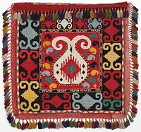Braided-net fringes, ikat band. Bag back: pieced, printed stripes and woven lining Overall cross stitch embroidery in silk and synthetic threads on a printed cotton ground. Crocheted fringe of cotton in two shades of red, with cotton tassels. there is an unembellished red cotton band at the top, which is covered by the fringe. The top opening of the bag is bound in silk/cotton ikat. The back of the bag is composed of two layers of printed cotton fabric. One intact hanging cord is present at the PR. a square 12.25" at center with white motif on red background with green, yellow, black, blue elements. Outer border: on black background multi-colored motifs.. Original from the Minneapolis Institute of Art.