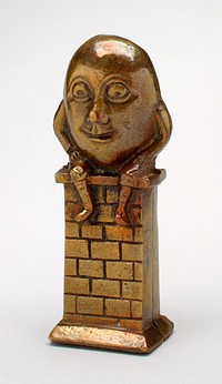 brass egg with face, arms and legs, Humpty Dumpty smiling and sitting on a brick wall; made in 2 parts- front and back. Original from the Minneapolis Institute of Art.