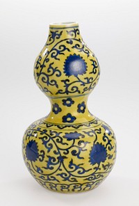 blue underglaze, yellow overglaze; set on a recessed base with rounded lower section that narrows at middle, bulbous upper section tapering to straight mouth; lotus scroll decoration on both sections with upper enclosed within line borders, lower within a petal lappet border above and cloud scroll border below; waist painted with six-petalled flowers. Original from the Minneapolis Institute of Art.