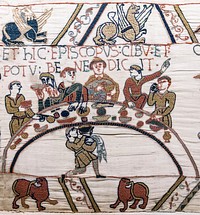 Bayeux Tapestry - Scene 43: Bishop Odo blesses the first banquet that Duke William and the Norman Barons hold on English soil. The bishop is recognisable by his tonsure and also by the fish in front of him.Titulus: ET HIC EPISCOPUS CIBU[M] ET POTU[M] BENEDICIT (And here the bishop blesses the food and drink)