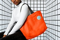 Woman using orange tote bag