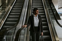 Businesswoman walking down escalator, getting off work