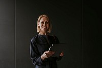 Cheerful businesswoman holding digital tablet